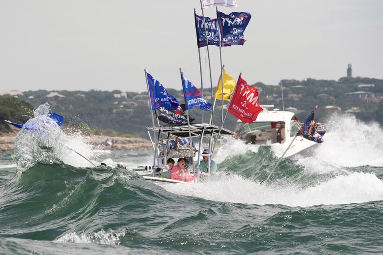 A boat is engulfed in waves from the large wakes of a flotilla of supporters of President Trump, during a boat parade on Lake Travis near Lakeway, Texas.  Bob Daemmrich via REUTERS